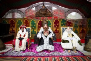Tres Reyes Magos sentados en un campamento decorado para Navidad