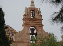 Campanario de una iglesia en Moncada con vegetación alrededor