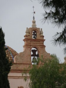Campanario de una iglesia en Moncada con vegetación alrededor