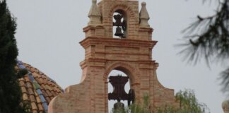 Campanario de una iglesia en Moncada con vegetación alrededor