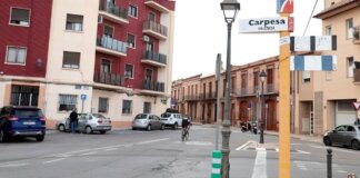 Vista de la calle principal en Carpesa, Valencia con edificios y vehículos