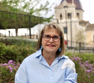 Conxa García, alcaldesa de Picassent, sonríe en un entorno natural.