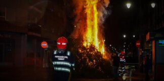 Hoguera de Sant Antoni Abat encendida en Torrent con bomberos presentes