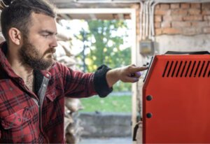 Hombre ajustando un generador eléctrico en un entorno doméstico