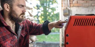 Hombre ajustando un generador eléctrico en un entorno doméstico