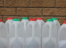 Gestión de envases impulsa la economía circular Botellas de plástico blancas con tapas de colores en una pared de ladrillo