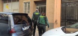Dos agentes de la Guardia Civil ingresando a un edificio.