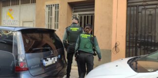 Dos agentes de la Guardia Civil ingresando a un edificio.