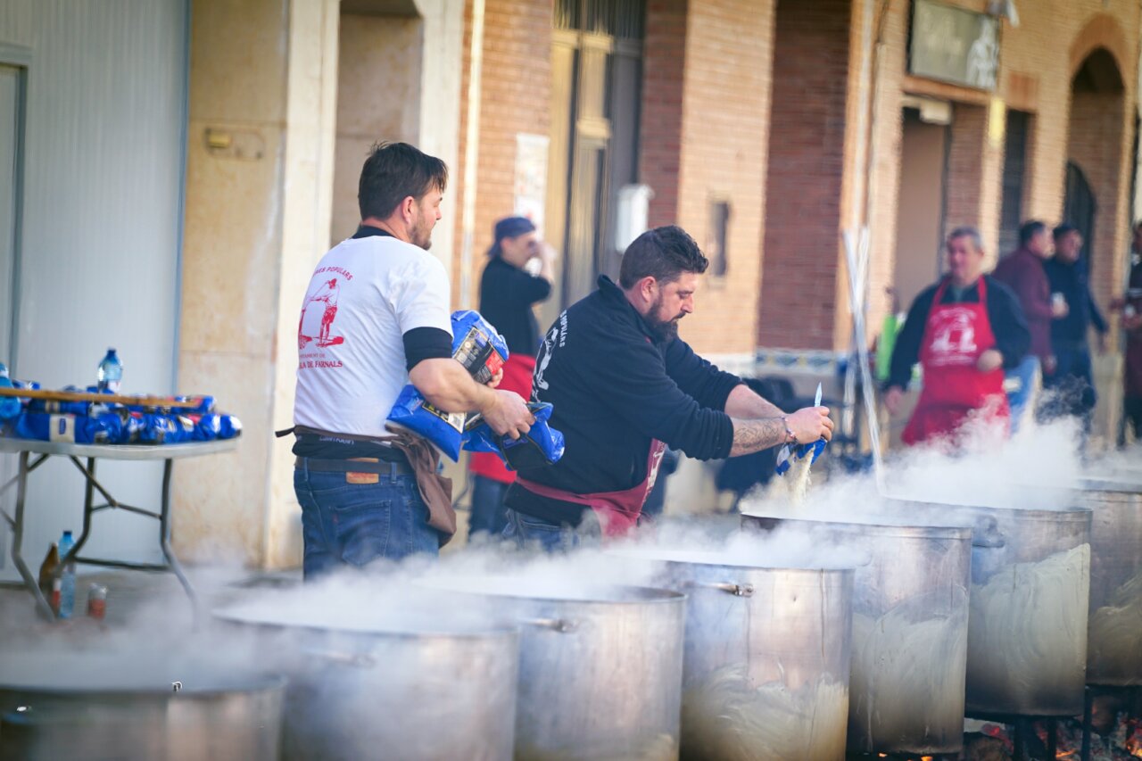 Hombres cocinando en grandes calderas en Pobla de Farnals