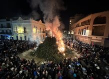 Gran hoguera durante la fiesta de Sant Antoni en Rafelbunyol con multitud de asistentes.