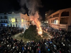 Gran hoguera durante la fiesta de Sant Antoni en Rafelbunyol con multitud de asistentes.