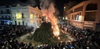 Gran hoguera durante la fiesta de Sant Antoni en Rafelbunyol con multitud de asistentes.