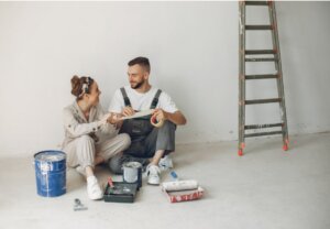 Pareja sonriente trabajando en la reforma de su casa