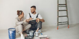 Pareja sonriente trabajando en la reforma de su casa