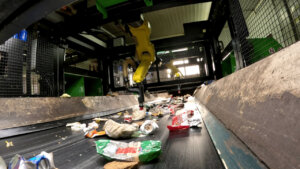 Brazos robóticos seleccionando residuos en planta de reciclaje