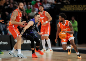 Jugadores de Valencia Basket y Surne Bilbao en acción durante un partido de baloncesto.