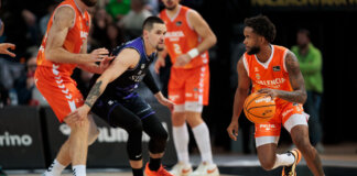 Jugadores de Valencia Basket y Surne Bilbao en acción durante un partido de baloncesto.