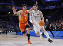 Jugador del Real Madrid driblando mientras es defendido por un jugador de Valencia Basket