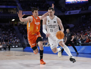 Jugador del Real Madrid driblando mientras es defendido por un jugador de Valencia Basket