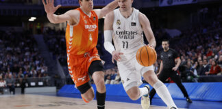 Jugador del Real Madrid driblando mientras es defendido por un jugador de Valencia Basket