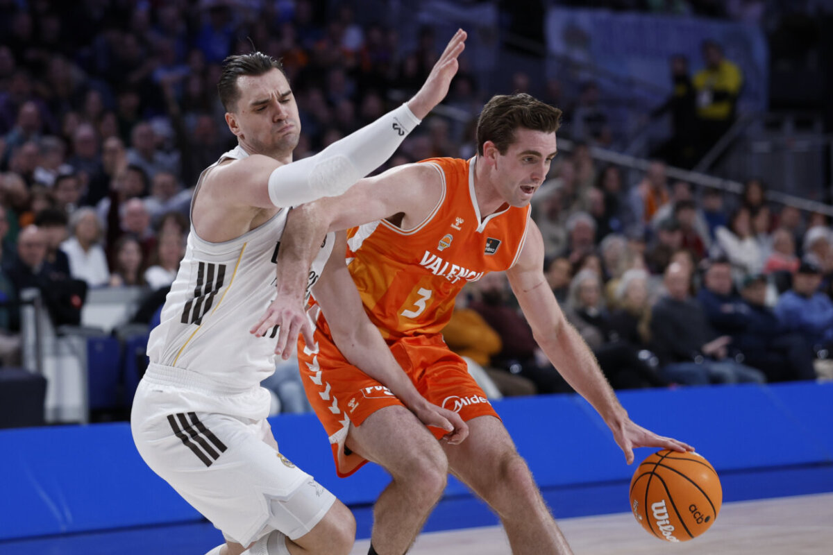 Jugadores de baloncesto compiten en un partido entre Real Madrid y Valencia Basket.