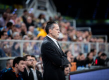 La serenidad como seña de identidad del Valencia Basket de Pedro Martínez Entrenador Pedro Martínez observando un partido de baloncesto con seriedad.