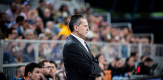 La serenidad como seña de identidad del Valencia Basket de Pedro Martínez Entrenador Pedro Martínez observando un partido de baloncesto con seriedad.