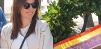 Sonia Borruey posando junto a una corona de flores con la bandera de Paterna