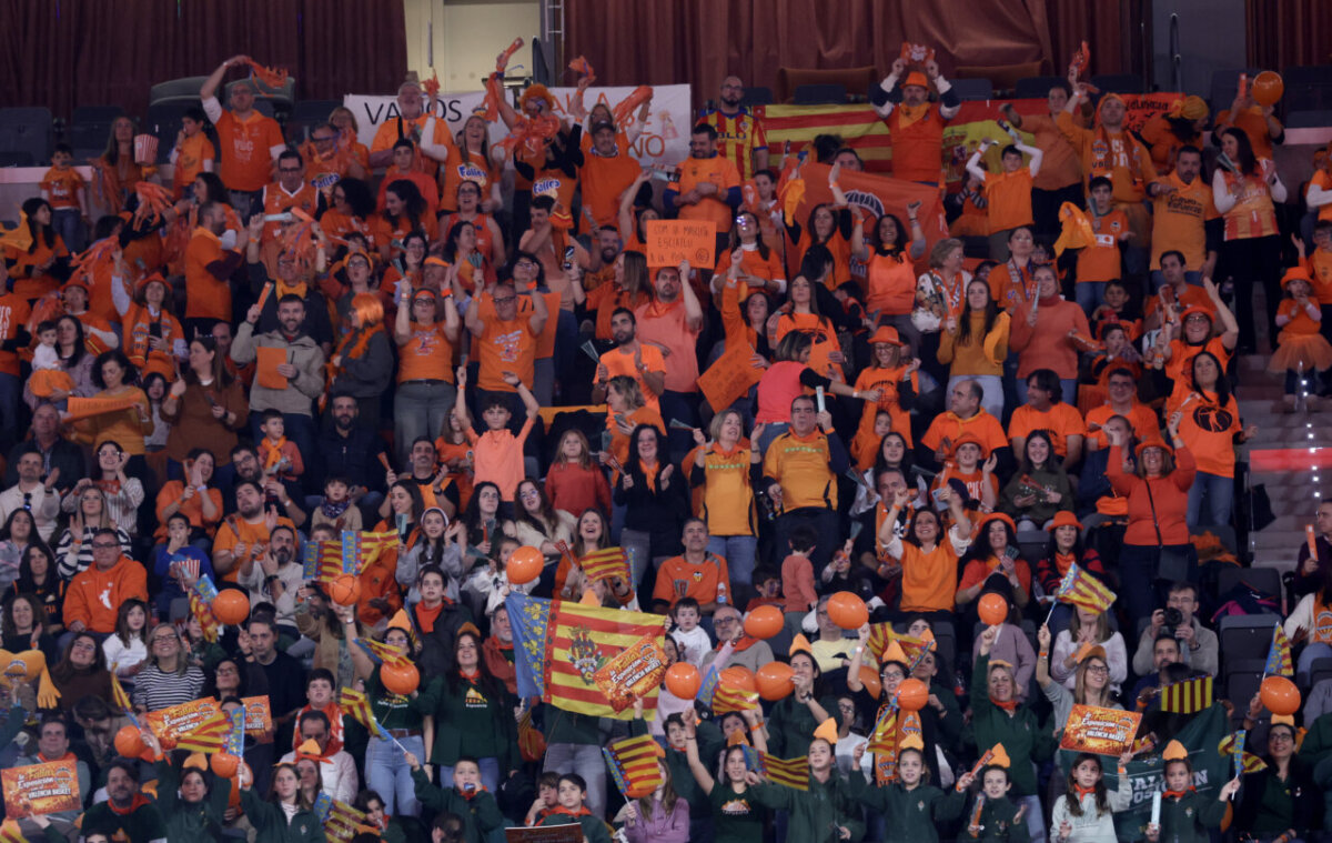 Aficionados de Valencia Basket animando en el Roig Arena con camisetas naranjas.