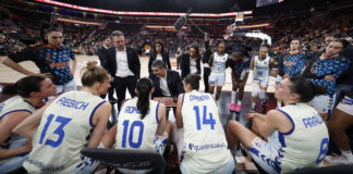 Entrenador y jugadoras de Valencia Basket discutiendo estrategia en un partido