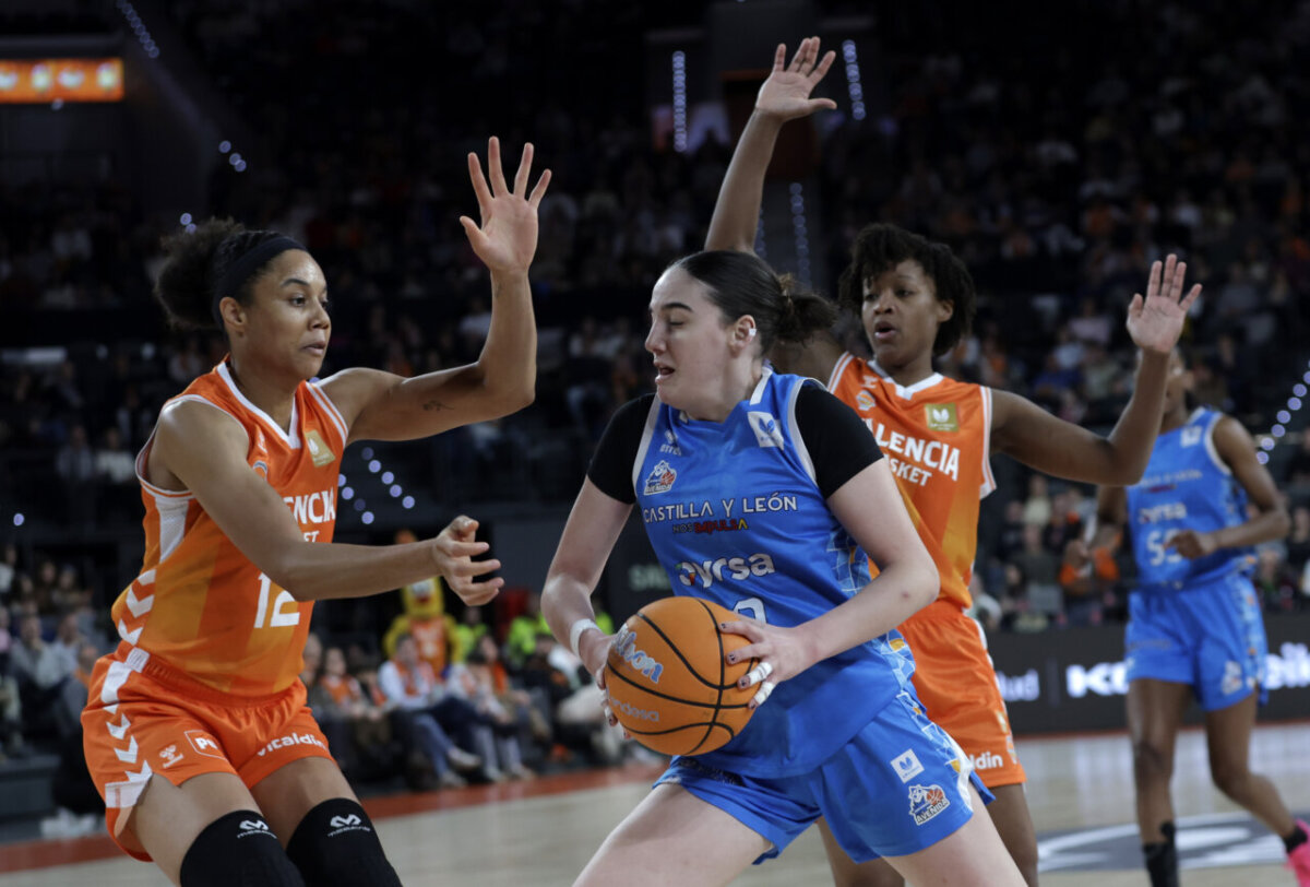 Jugadoras de Valencia Basket defendiendo a una jugadora de Perfumerías Avenida durante un partido.