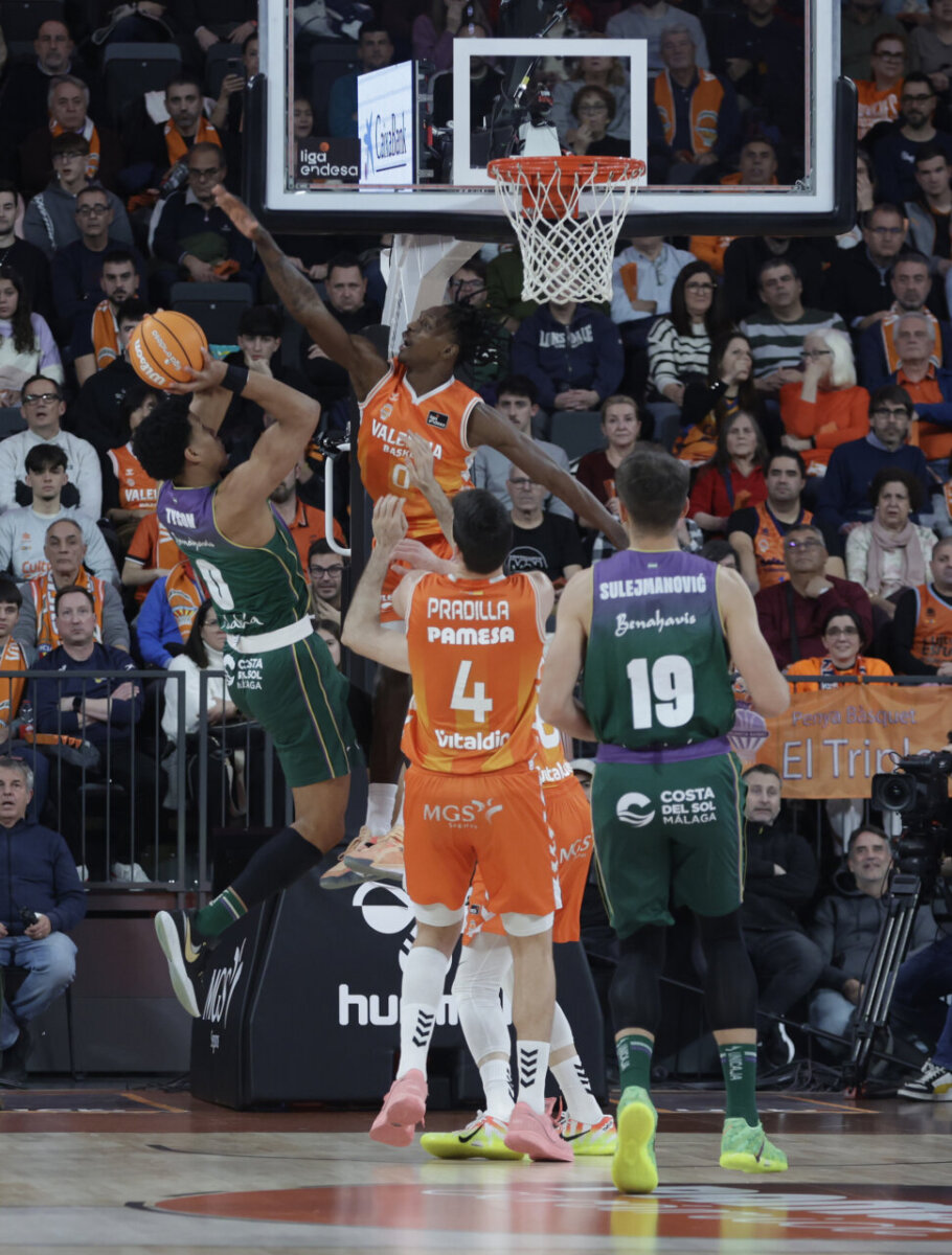 Jugadores de Valencia Basket defendiendo un tiro de Unicaja en el Roig Arena.