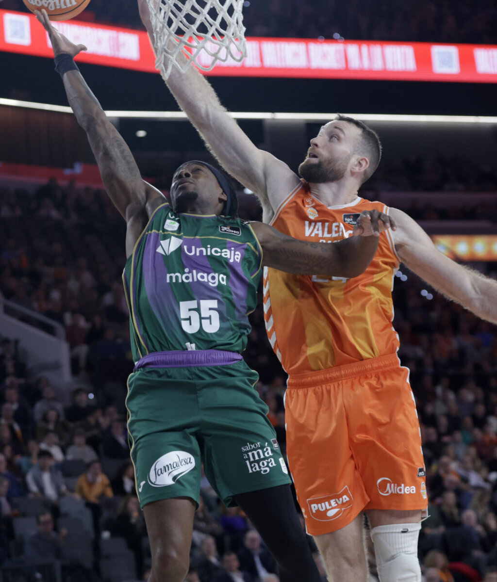 Jugadores de Valencia Basket y Unicaja compiten en un partido de baloncesto.