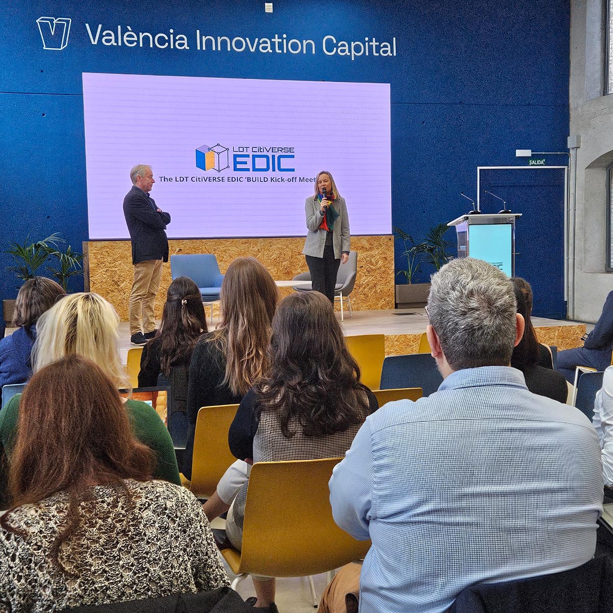 Reunión de lanzamiento del proyecto BUILD en València con presentadores en el escenario.