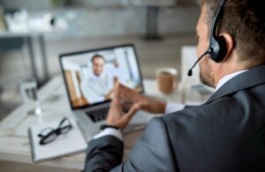 Un profesional participa en una videoconferencia utilizando tecnología avanzada.