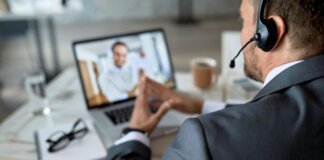 Un profesional participa en una videoconferencia utilizando tecnología avanzada.