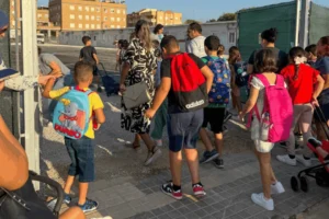 Niños y adultos entrando al CEIP Orba en Alfafar