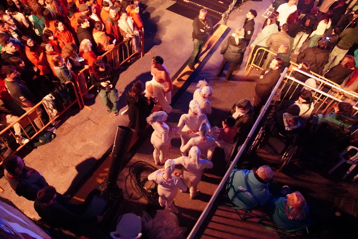 Grupo de personas en un evento en Valencia con artistas en el escenario