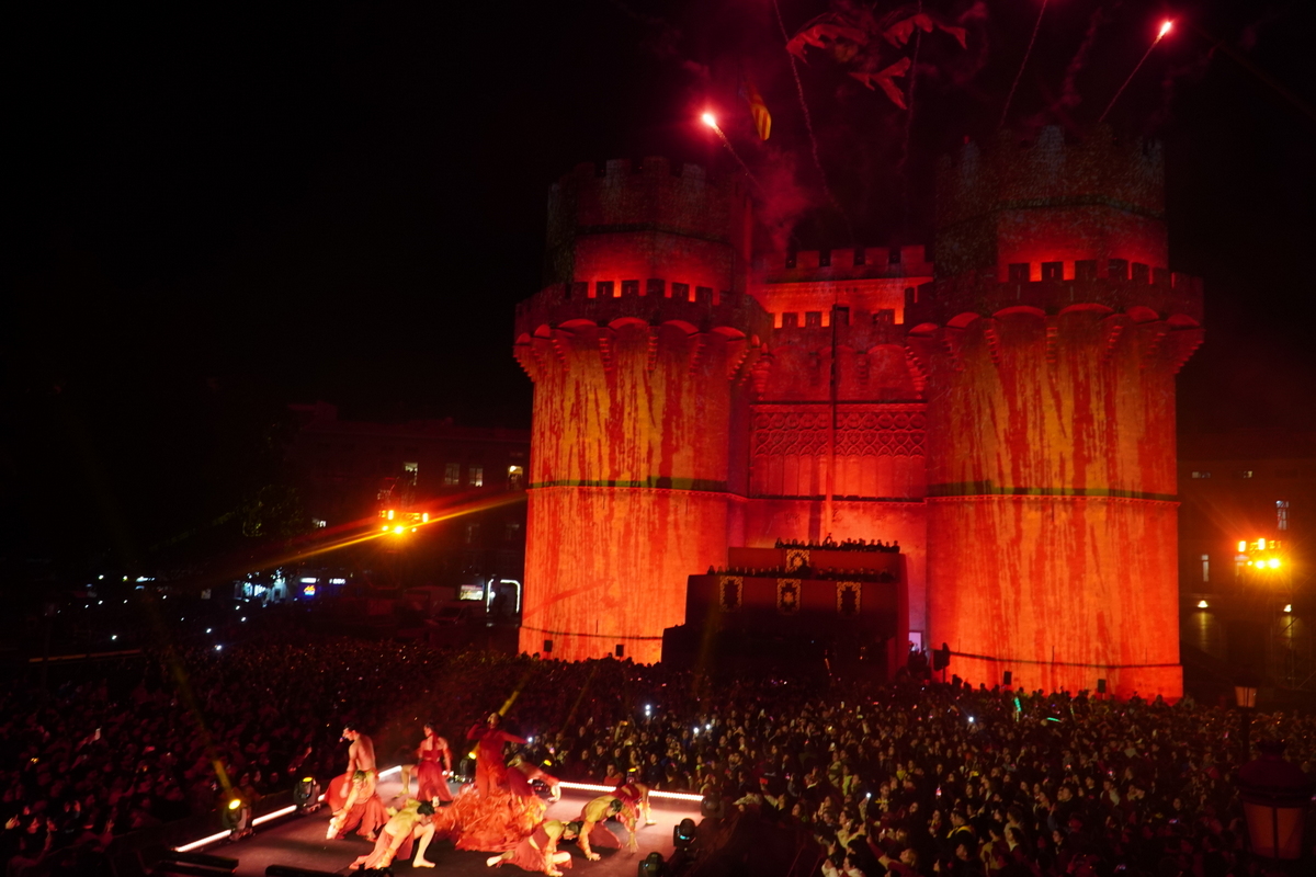 Espectáculo nocturno en Valencia con castillo iluminado y multitudes