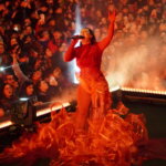 Artista actuando en un evento con un gran público animado