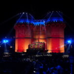 Multitud celebrando el Domingo de Cridida en Valencia con luces y castillo