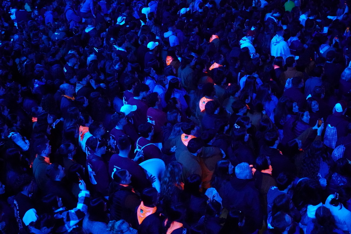 Multitud de personas en un evento nocturno con luces azules