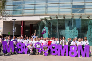Grupo de mujeres celebrando el 8M en Torrent con letras grandes de 8M