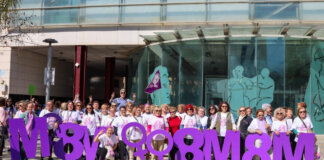 Grupo de mujeres celebrando el 8M en Torrent con letras grandes de 8M