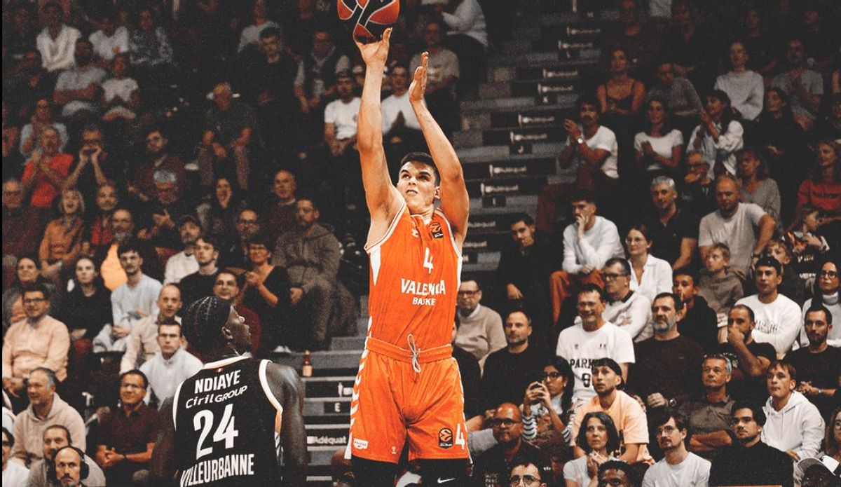 Jugador de Valencia Basket lanzando a canasta durante un partido emocionante.