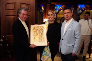 Antonio Camaró y Nadia Zein sosteniendo una obra de arte en un evento cultural