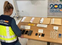 Agente de policía revisando evidencia en una mesa con documentos y objetos