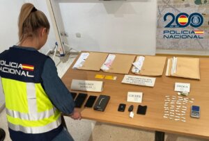 Agente de policía revisando evidencia en una mesa con documentos y objetos