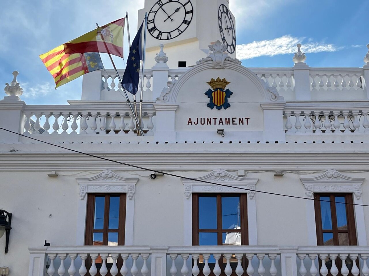 Fachada del Ayuntamiento de Meliana con banderas y reloj