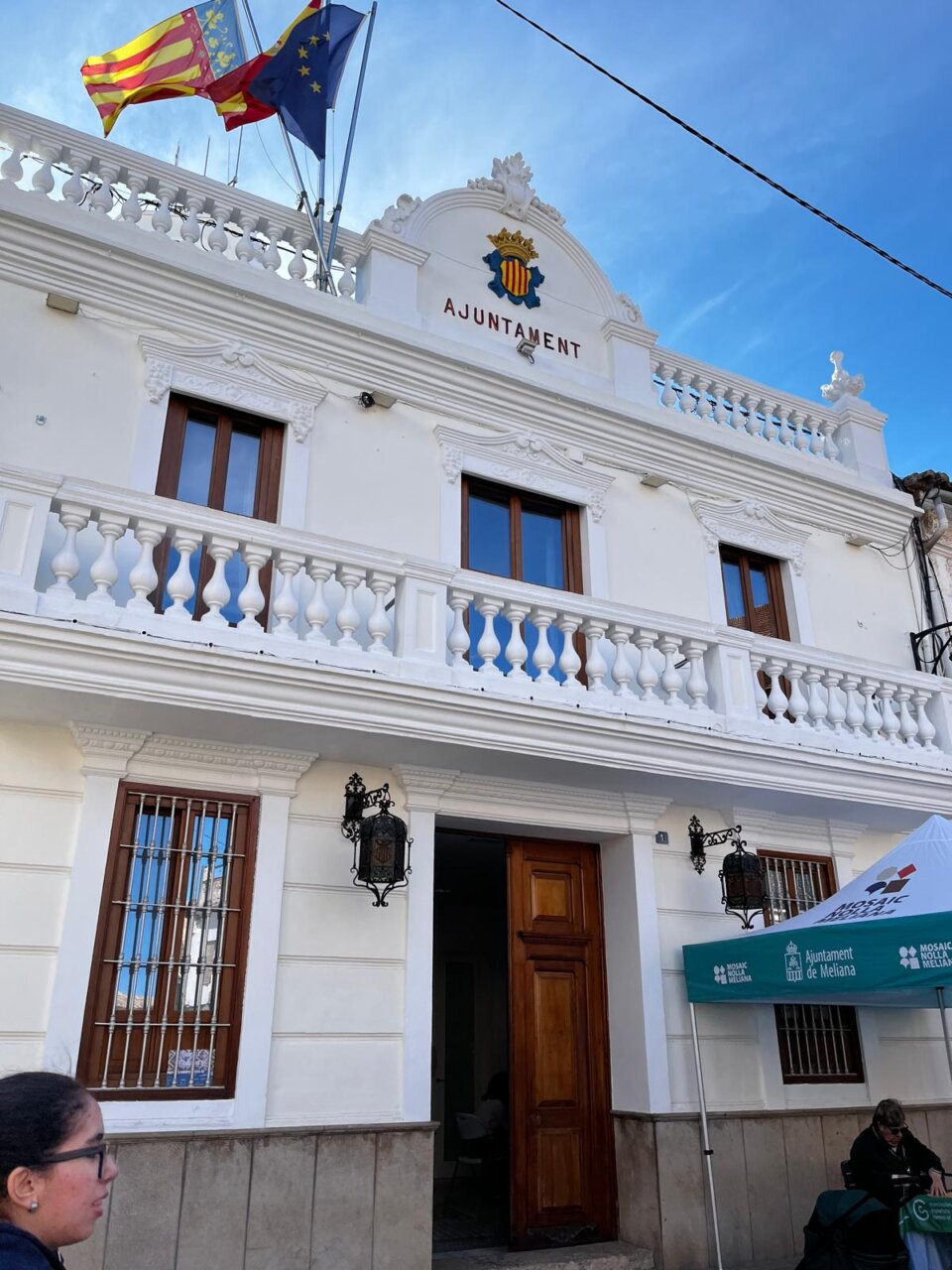 Vista del Ayuntamiento de Meliana con banderas y arquitectura clásica.